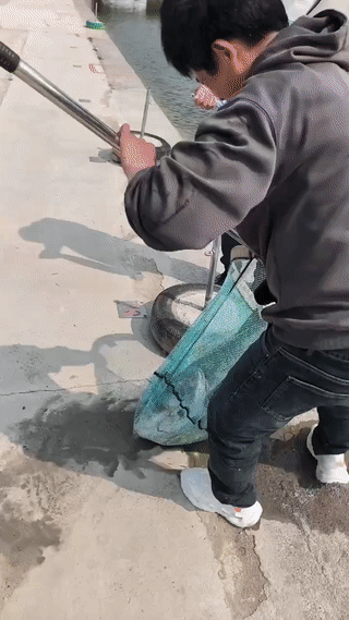 男子在鱼塘钓到一条大鱼后，非要将大鱼用双手抱起来拍照显摆？
结果大鱼突然挣扎了一