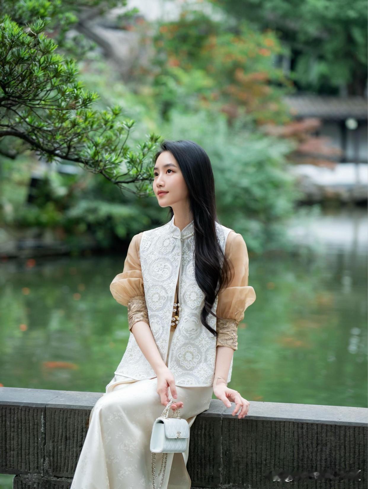 古典园林中的优雅女子，白纱裙摆随风飘逸，宛如画中人。