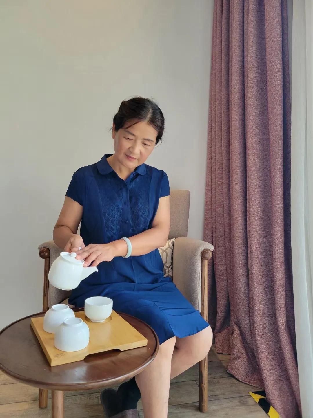 她的容颜如花般绽放，眉眼间流露出淡淡的温柔与雅致。一头乌黑亮丽的长发轻轻垂落，随
