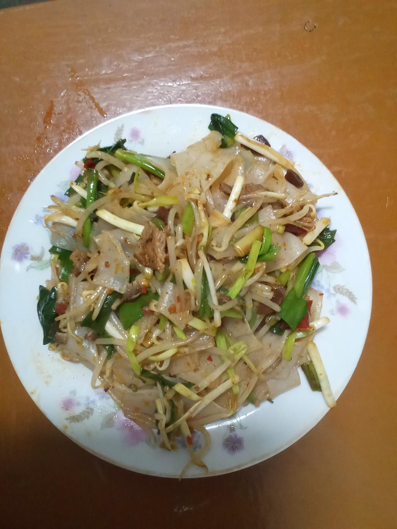 这盘炒米皮，是家常菜里最治愈的模样。米皮被大火爆炒得软糯又带点韧劲，吸饱了酱汁的