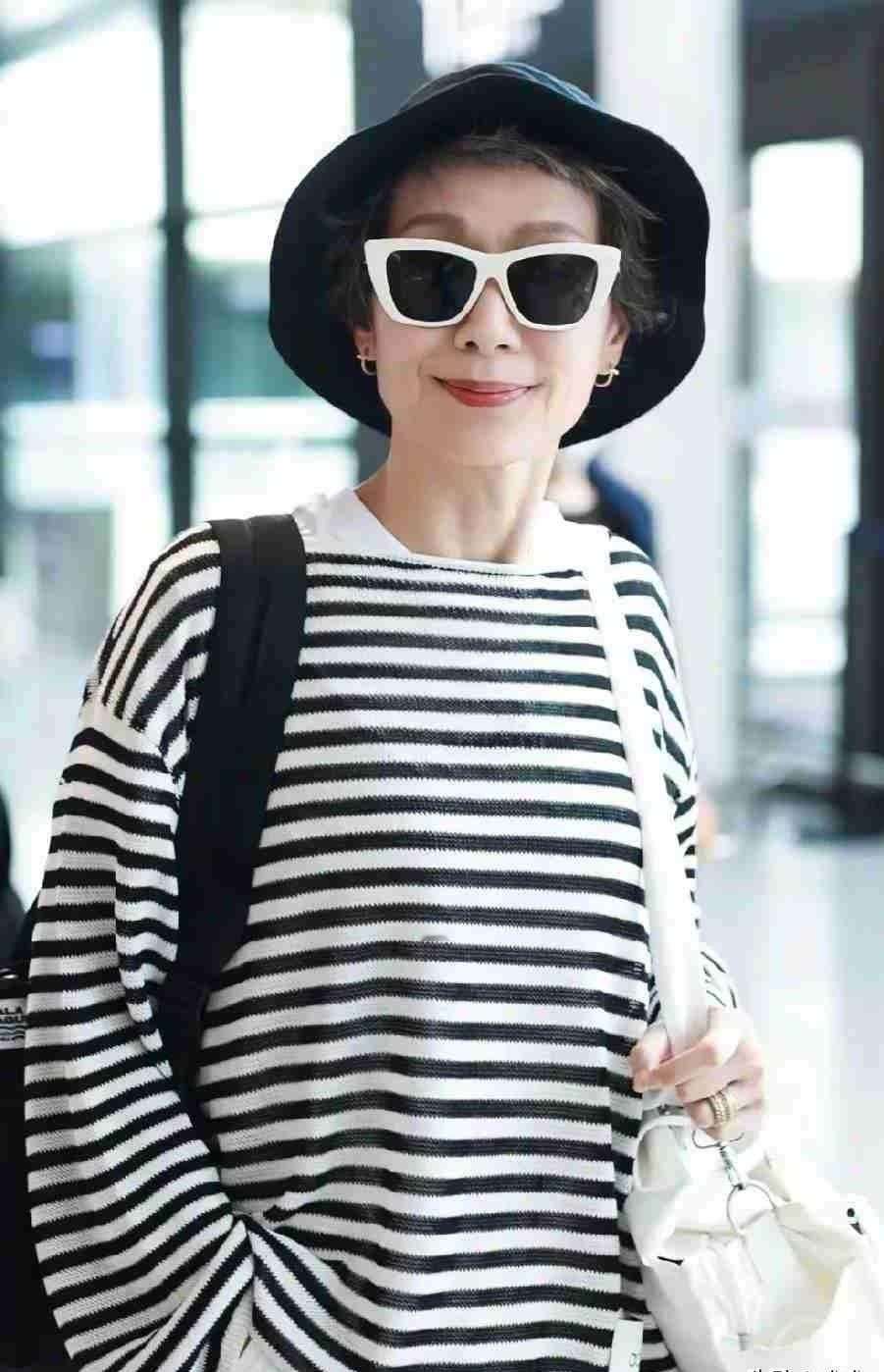 叶童穿条纹衫推着行李过机场，没人认出来。
白头发藏在帽子里，墨镜一戴，谁看都像三