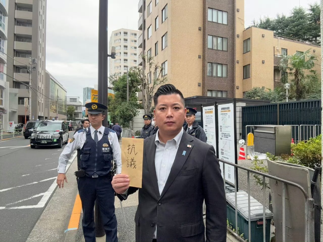 日本松户市一个议员跑到中国大使馆抗议薛剑的发言这位日本议员拿了一个写着“抗议”的