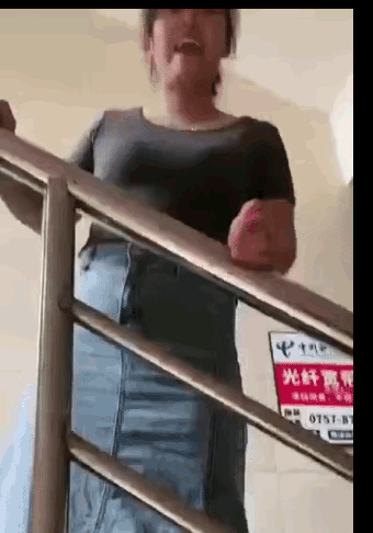 大姐在楼梯间瞪着眼睛，急着摆手比划着手势冲着老公大喊，大哥不知道发生了什么事情？
