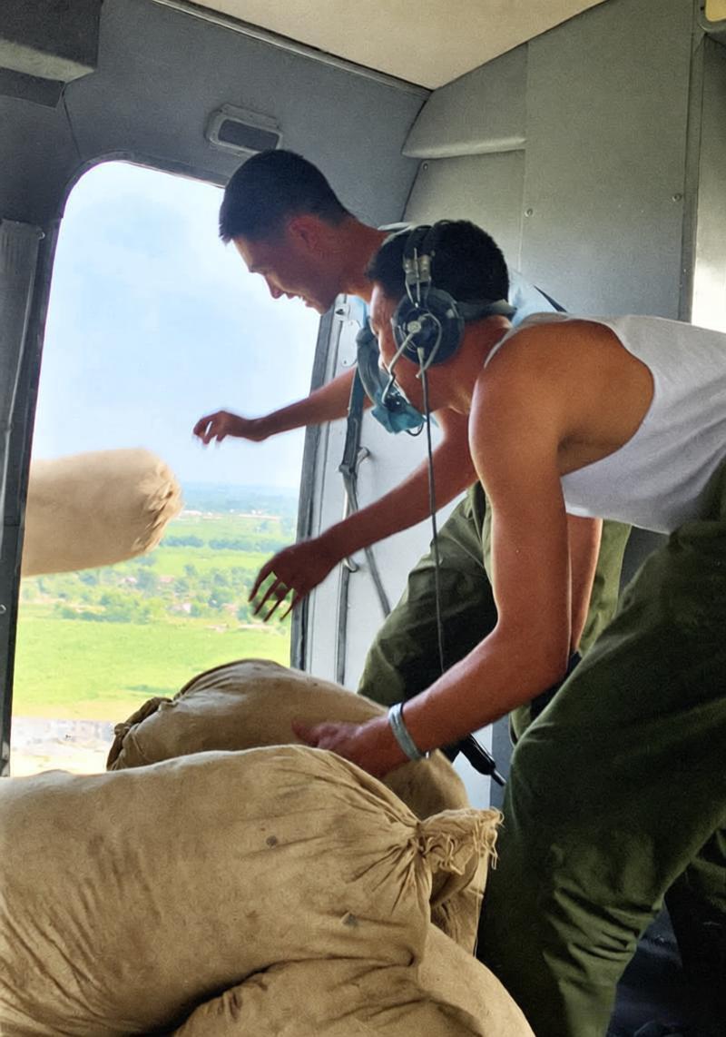 1976年，唐山地震期间，直升机空投救灾物资，局促的机舱内堆满鼓鼓的麻袋，两名解