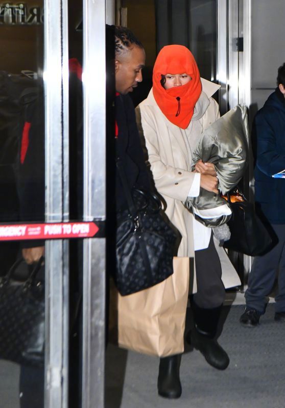 现身肯尼迪机场的赞达亚，抱着自己的枕头。这亮橙色的兜帽直接把隐匿转化为引人注目的