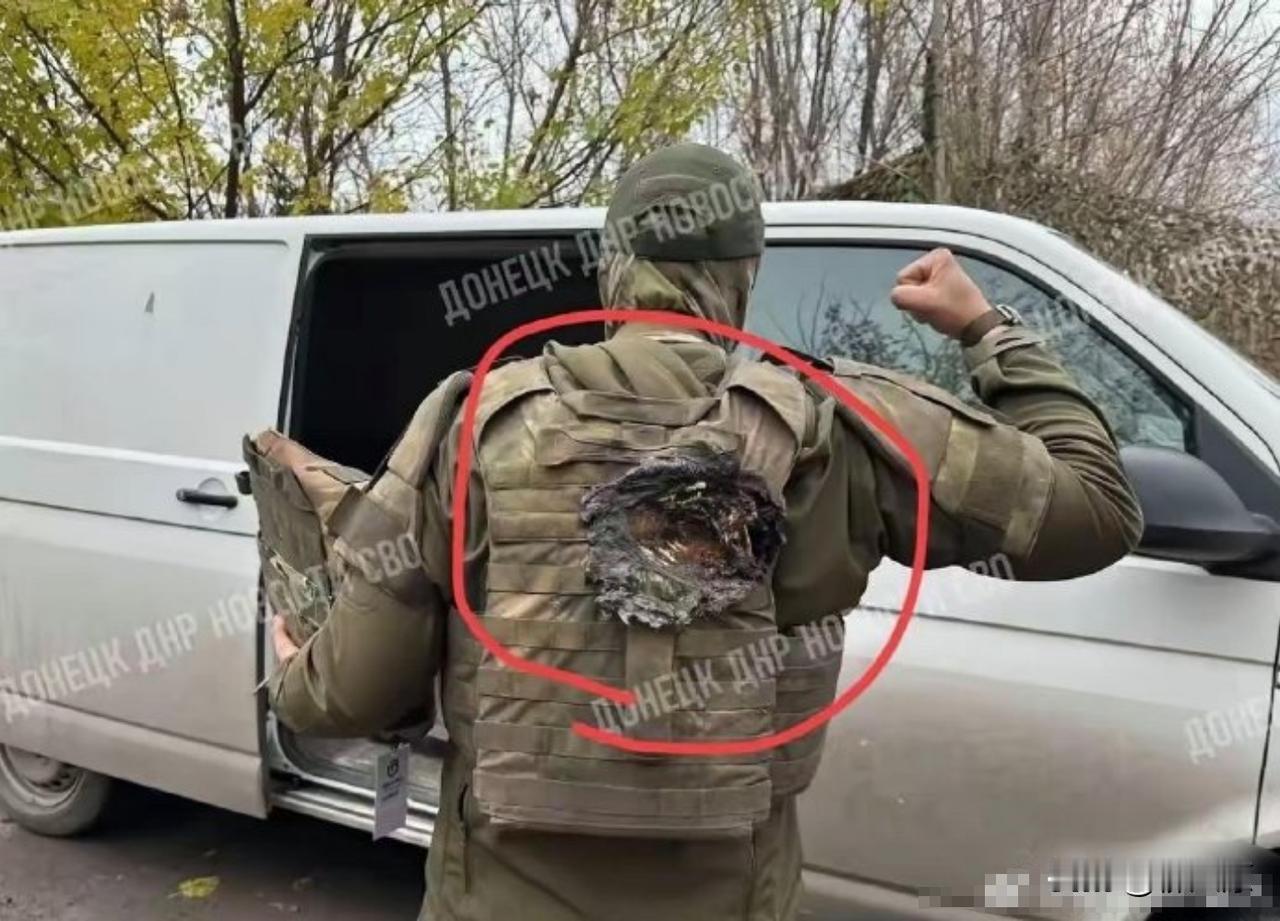 有个士兵向网友们展示了自己的后背，炫耀身上那件内置陶瓷插板的防弹衣救了他一命，你