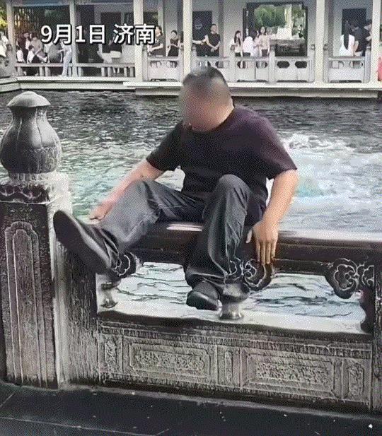 济南趵突泉景区，一大哥来到此处游玩时，因泉池景色优美，于是大哥坐在泉池护栏上摆好