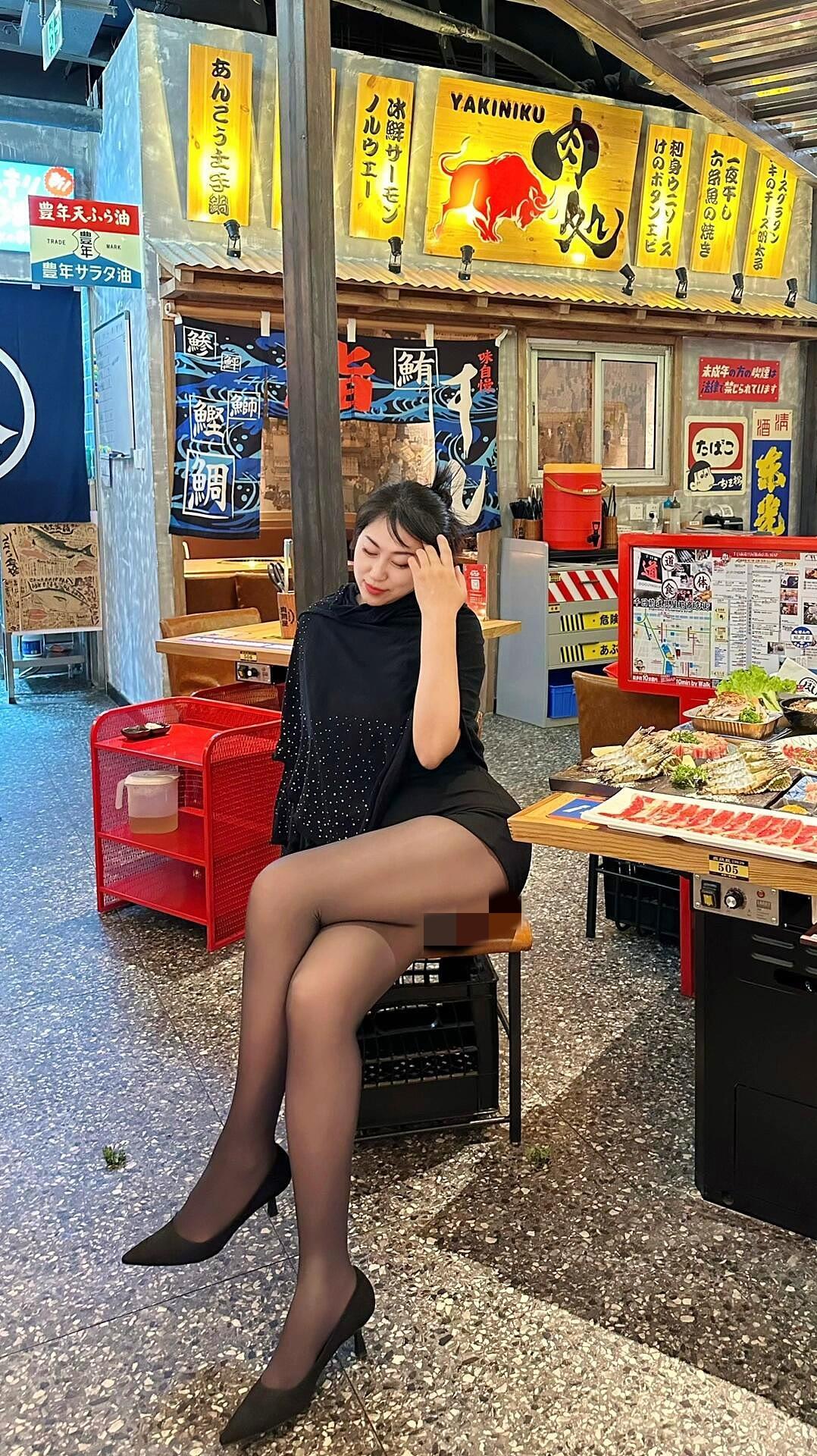 在街头小馆享受悠闲时光，黑裙与高跟鞋的优雅搭配，让人心动不已。