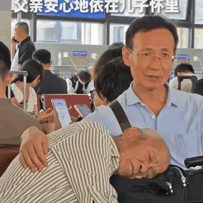 “火上人民日报了！”北京西站候车厅，女子看到一老人依偎在儿子怀里睡觉，觉得很温馨