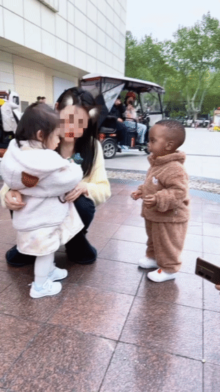 一位年轻的妈妈竟然在街头让自己的宝贝女儿和一个黑人小孩一起互动玩耍？
这样的行为