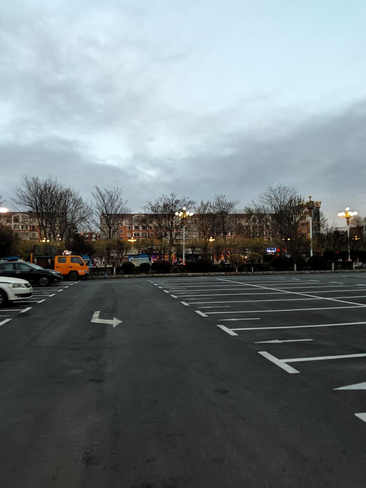 黄昏时分，空旷的停车场，静待归来的车辆。