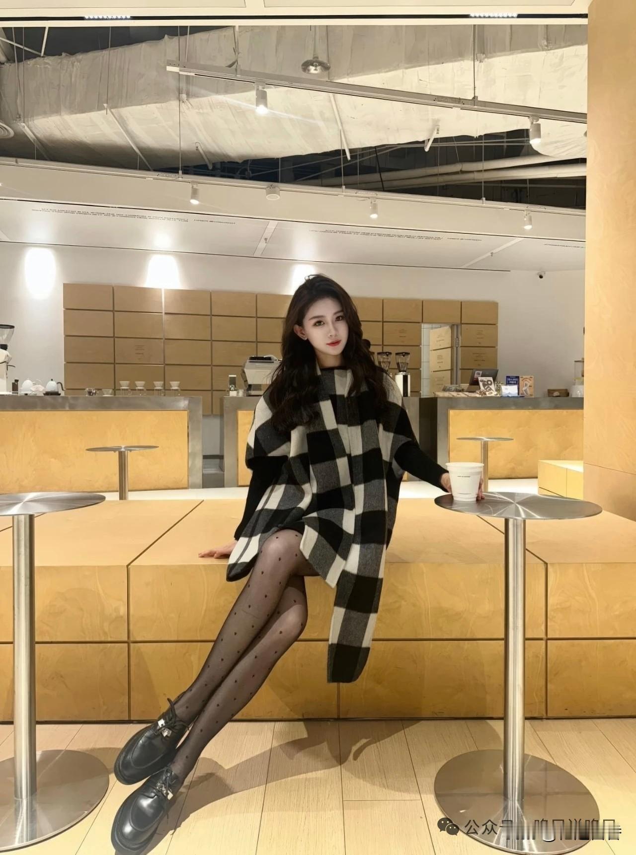 女孩坐在咖啡店的高脚凳上，看着镜头。