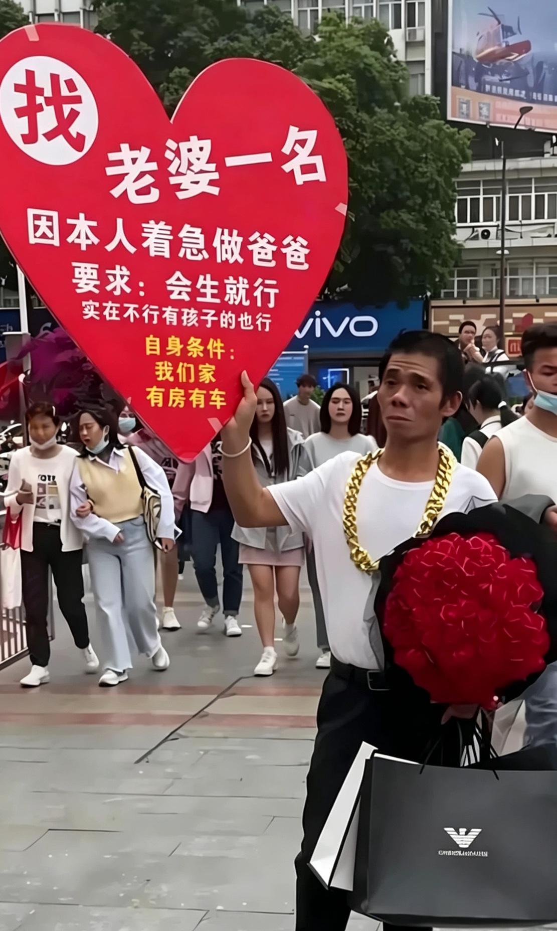 大哥举着爱心牌子上街征婚，诉求简单直白：着急当爸爸，对方只要会生就行，带孩子的女