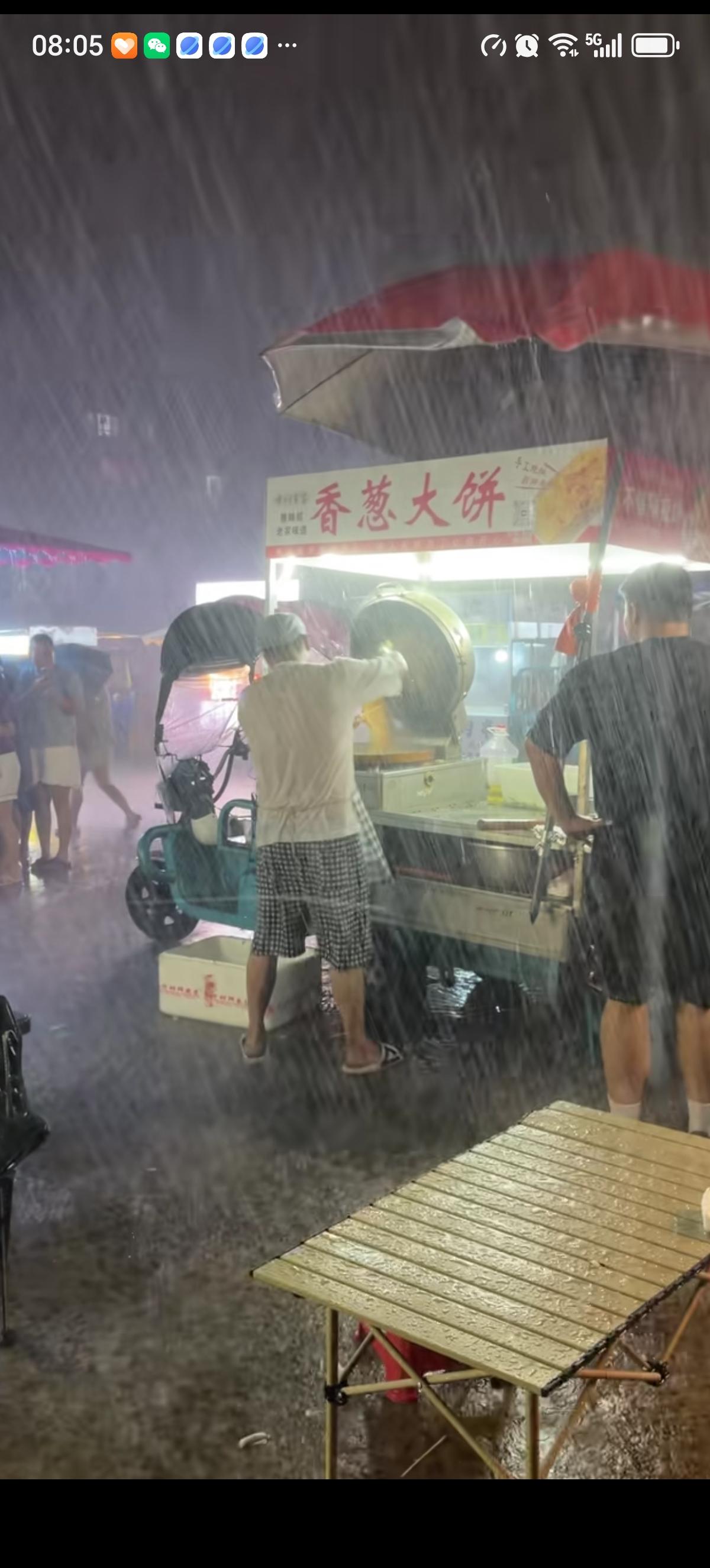 深夜天空下着大雨，香葱大饼的老板不但顶雨摆摊，还激情投入的做着大饼。主打只要有人