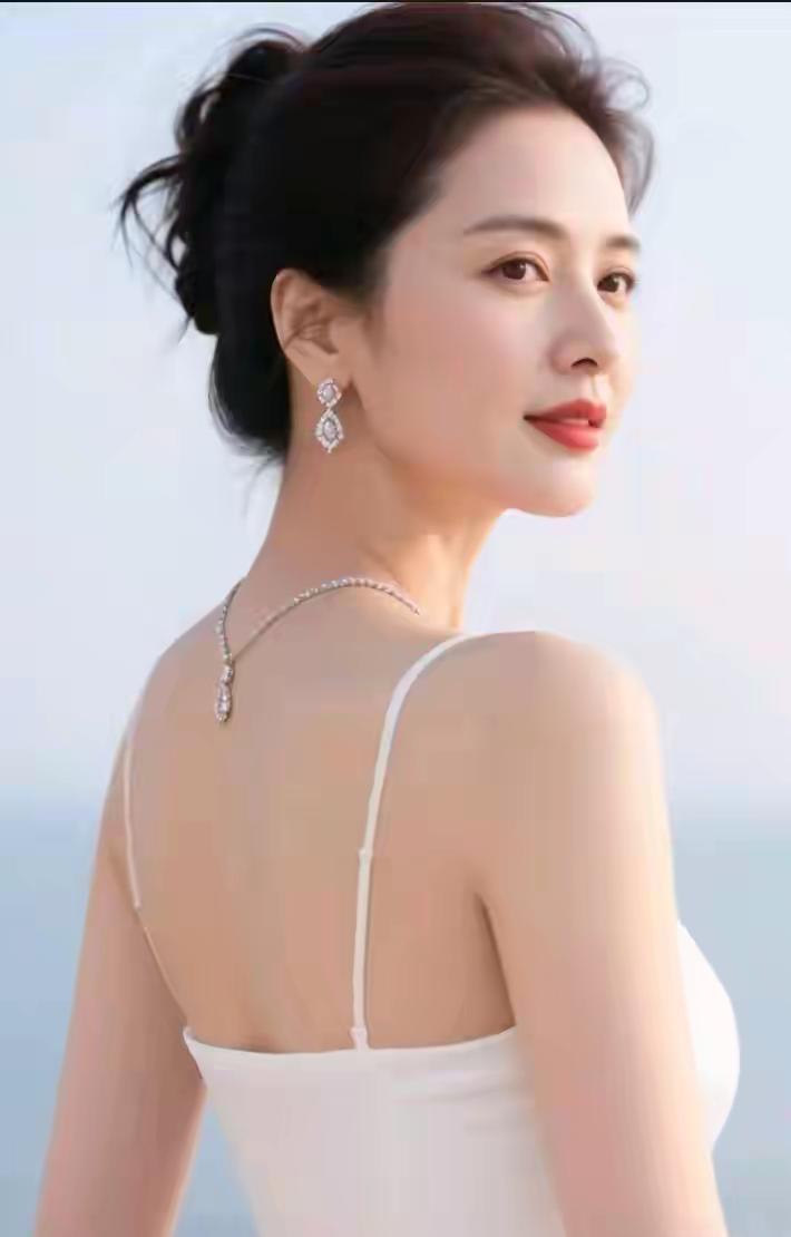 中年女性显娇容，
回眸一笑百媚生。
出水芙蓉亭亭立，
面若桃花抚柳轻。