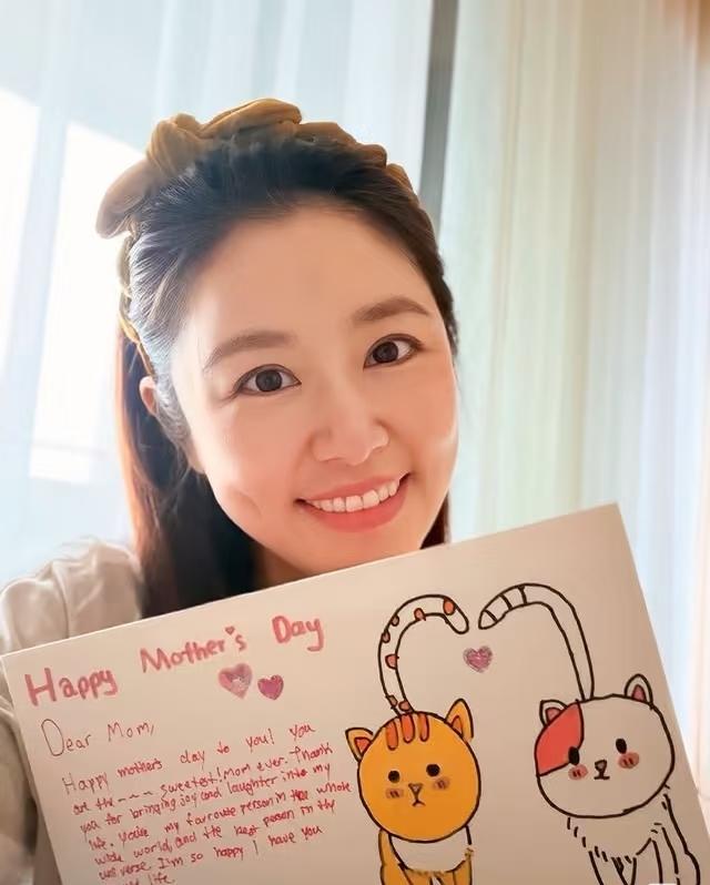 她拿着花笑起来的时候，还是当年那个娇俏的紫薇格格，她被女儿小海豚的心意狠狠暖到了