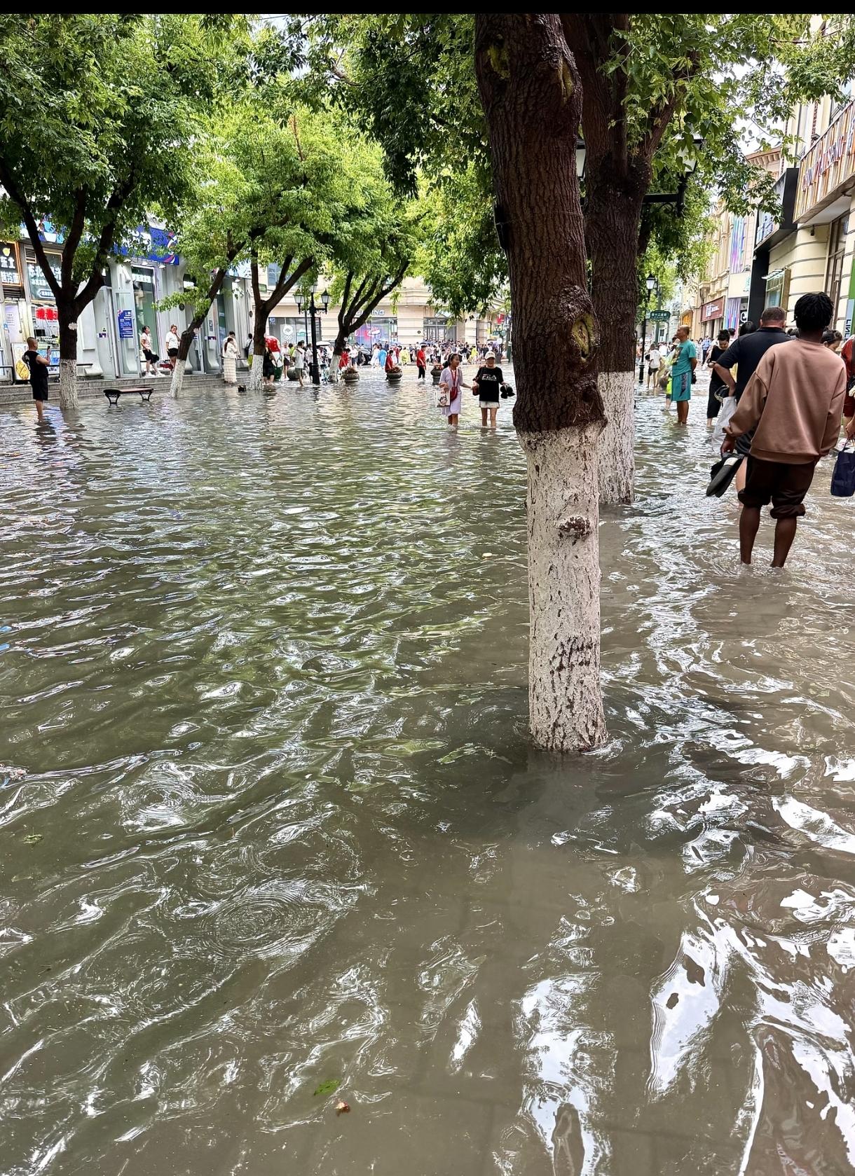 哈尔滨中央大街还能积水呀，一个俄罗斯金发女孩在泥坑里开心玩水！😂💦配上欧式建