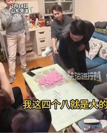 山东菏泽，年夜饭刚吃完，满桌的酒菜还没撤，瓜子糖果摆了一茶几，一家人热热闹闹围在