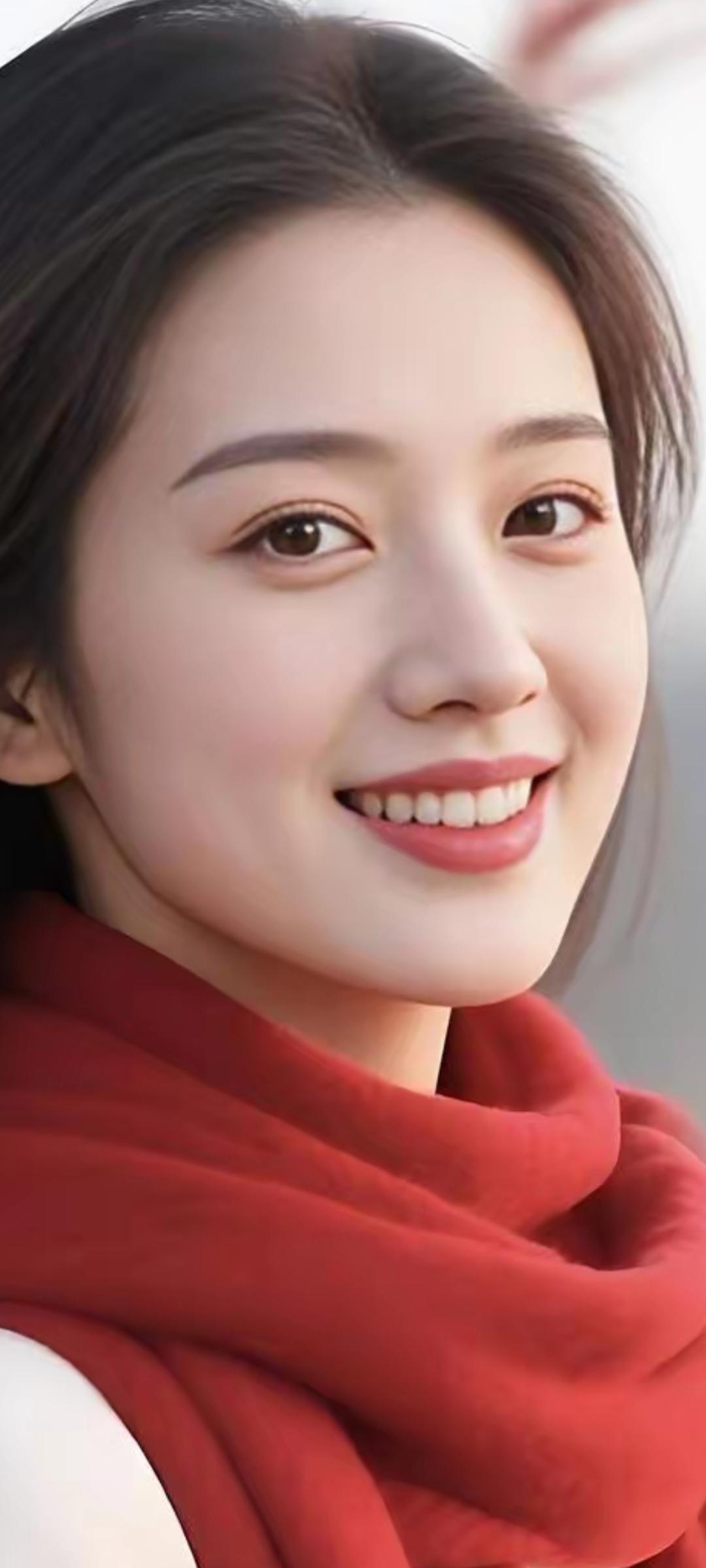 冬日暖阳下，甜美笑容绽放在红围巾的映衬下。