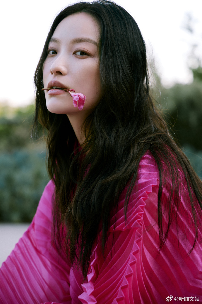 #倪妮玫红无袖连衣裙##倪妮衔花# 倪妮身着玫红无袖连衣裙，于日落中嘴角衔花，与