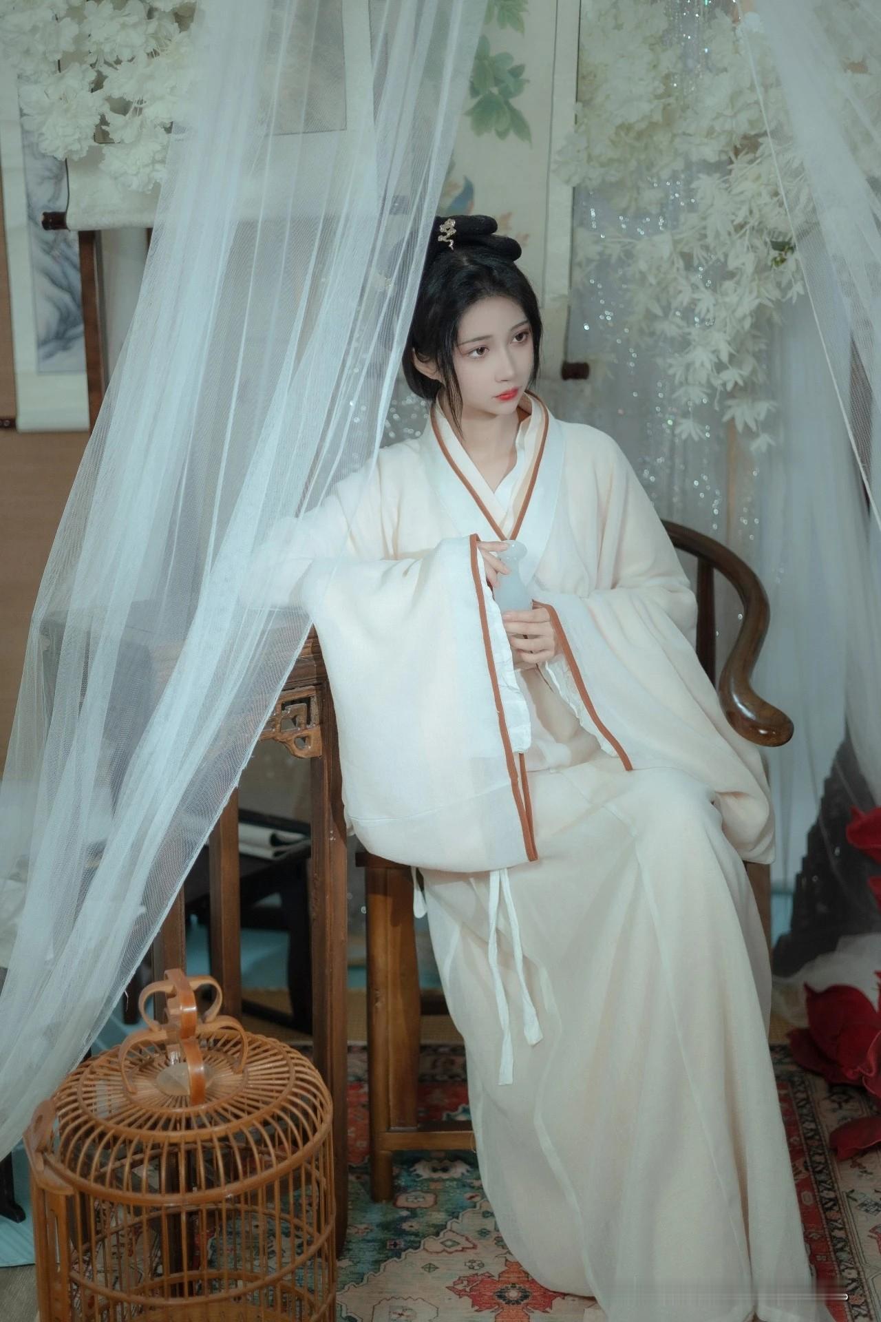 像是从山水画里走出的仙子。
身畔是碧波荡漾的江水，
身后是连绵起伏的青山。
不需