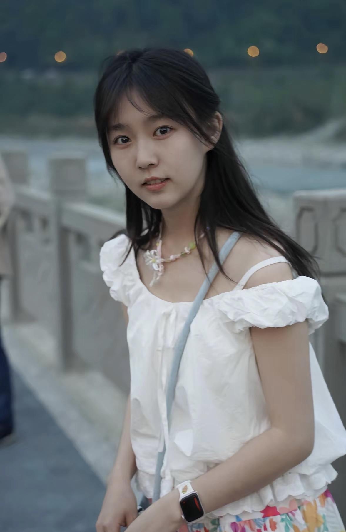 少女漫步在黄昏的桥上，温柔的灯光洒满她的脸庞。