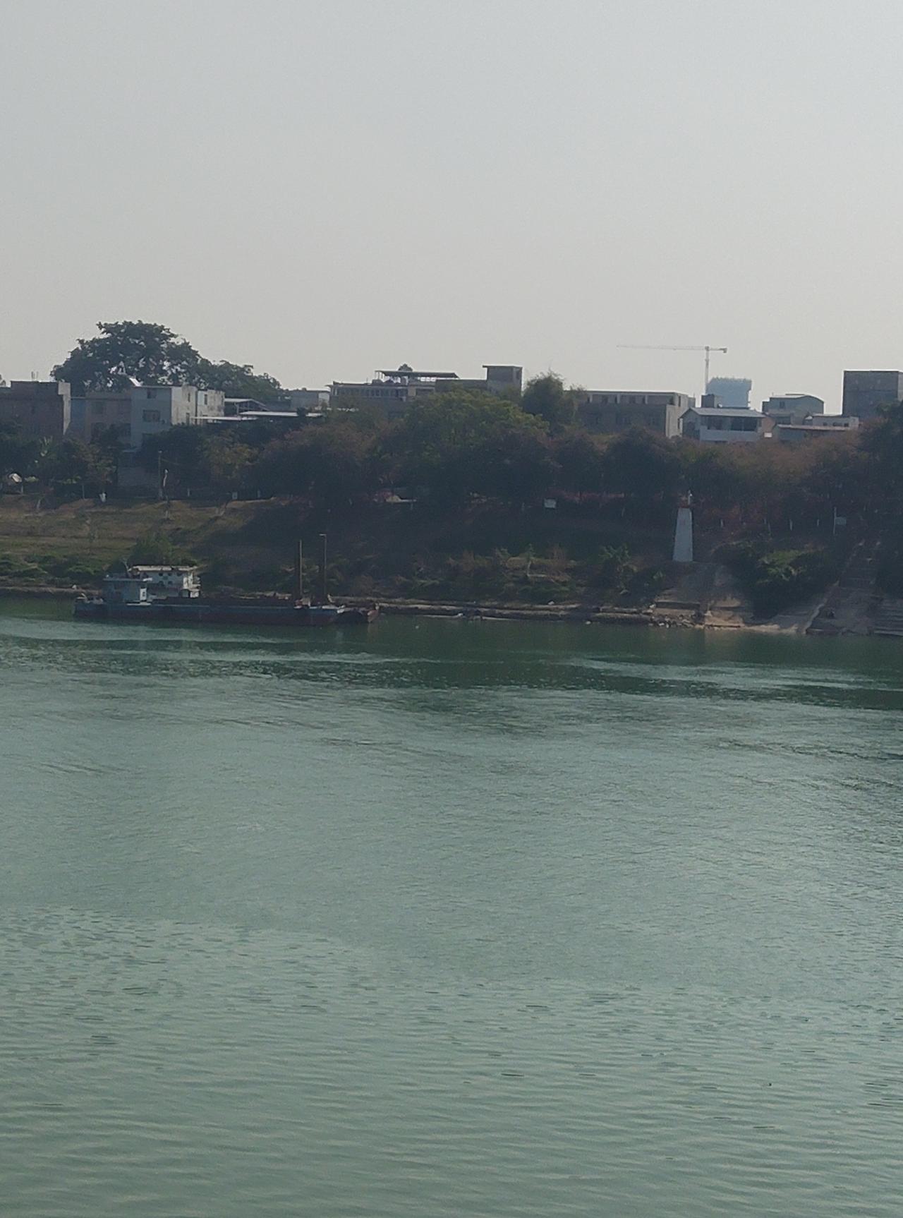 今天去滨江公园散步，
瞅见岸边停着艘旧船，
旁边还有个白灯塔，
看着还挺有年代感