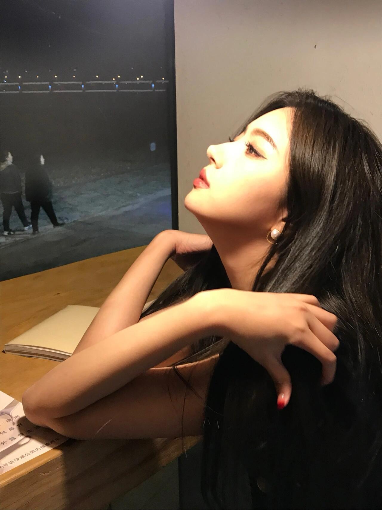 夜晚的灯光下，沉思的少女，静谧而美丽。