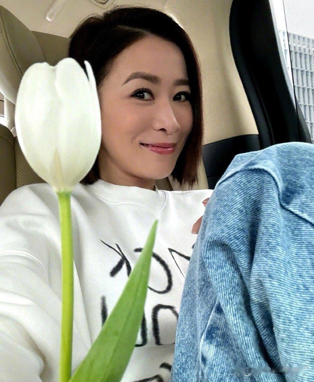佘诗曼分享美照，笑容灿烂如花。郁金香相伴，似乎在诉说她的快乐时光。 