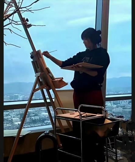 1974年出生的徐静蕾已经51岁了，一身宽容运动装，扎着马尾，在高楼豪宅里画画，