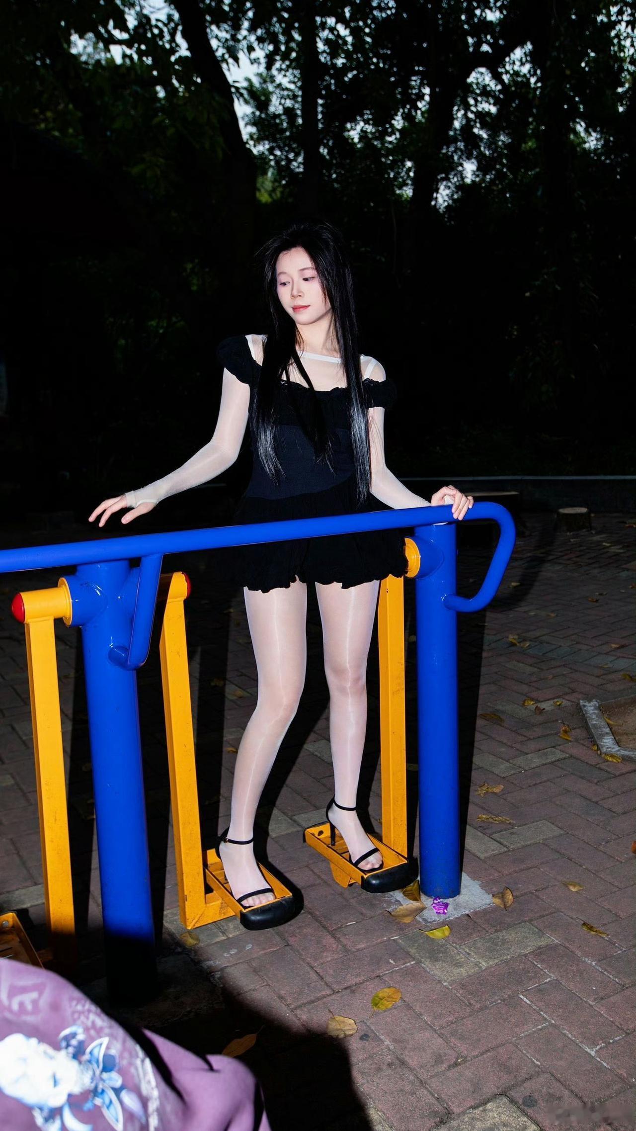 穿黑色衣服的女孩站在栏杆旁。