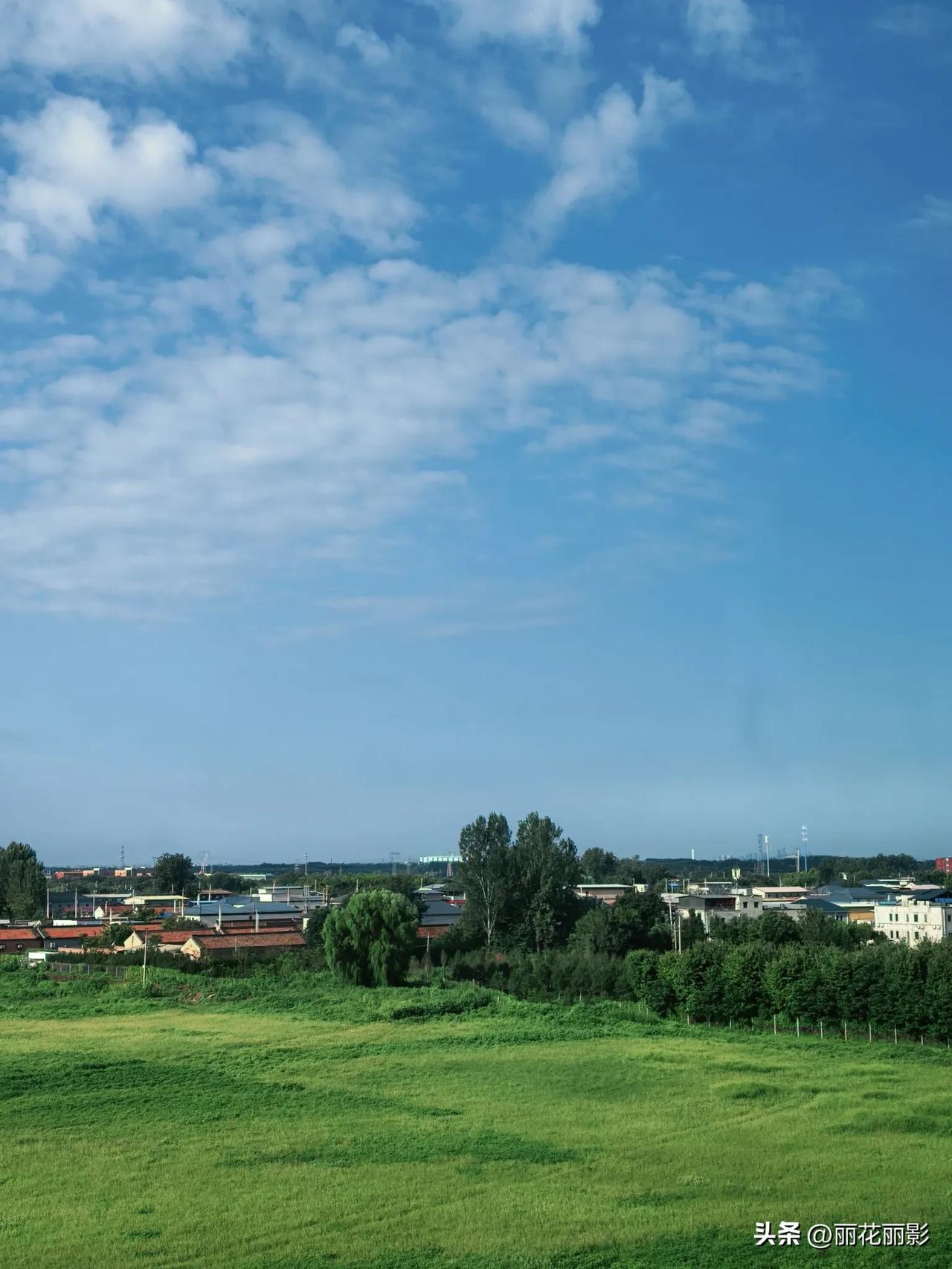 阴了两天下了一天的雨，今天终于晴天了。
蓝天上白云飘飘，地上绿草如茵，远处的村庄
