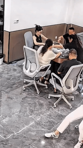 一女子坐在椅子上一边玩手机一边双脚蹬地向后退？
结果最后不小心连人带椅子一起坠下