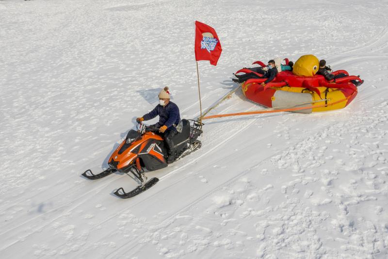 辽宁抚顺的雪地“真人贪吃蛇”玩法火出圈啦！游客们坐在雪地圈上，抱着后面人的鞋子，