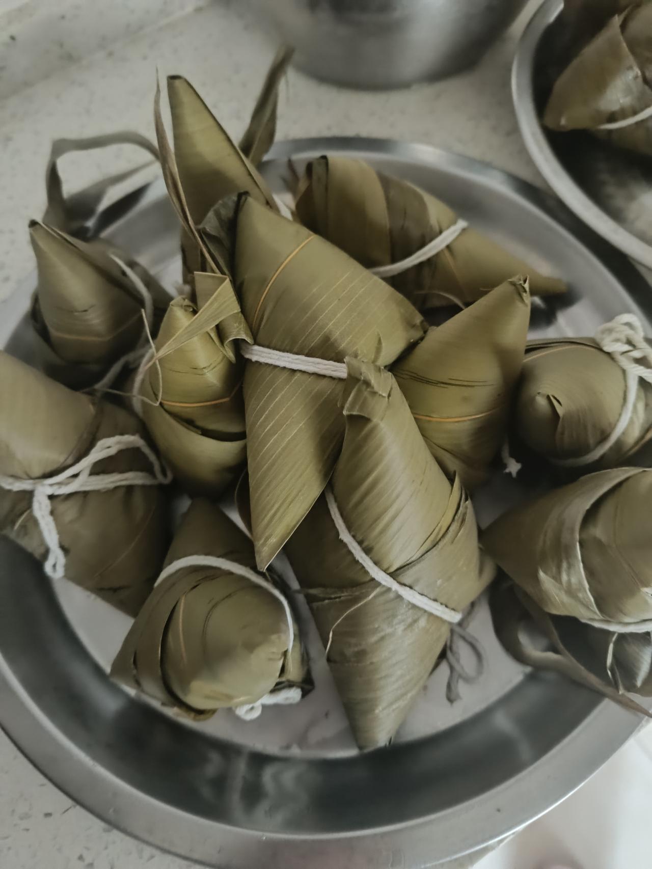 糯米泡得莹白，粽叶清香沁人，爸爸坐在小板凳上，一折一卷，填米、塞枣、扎线，动作利