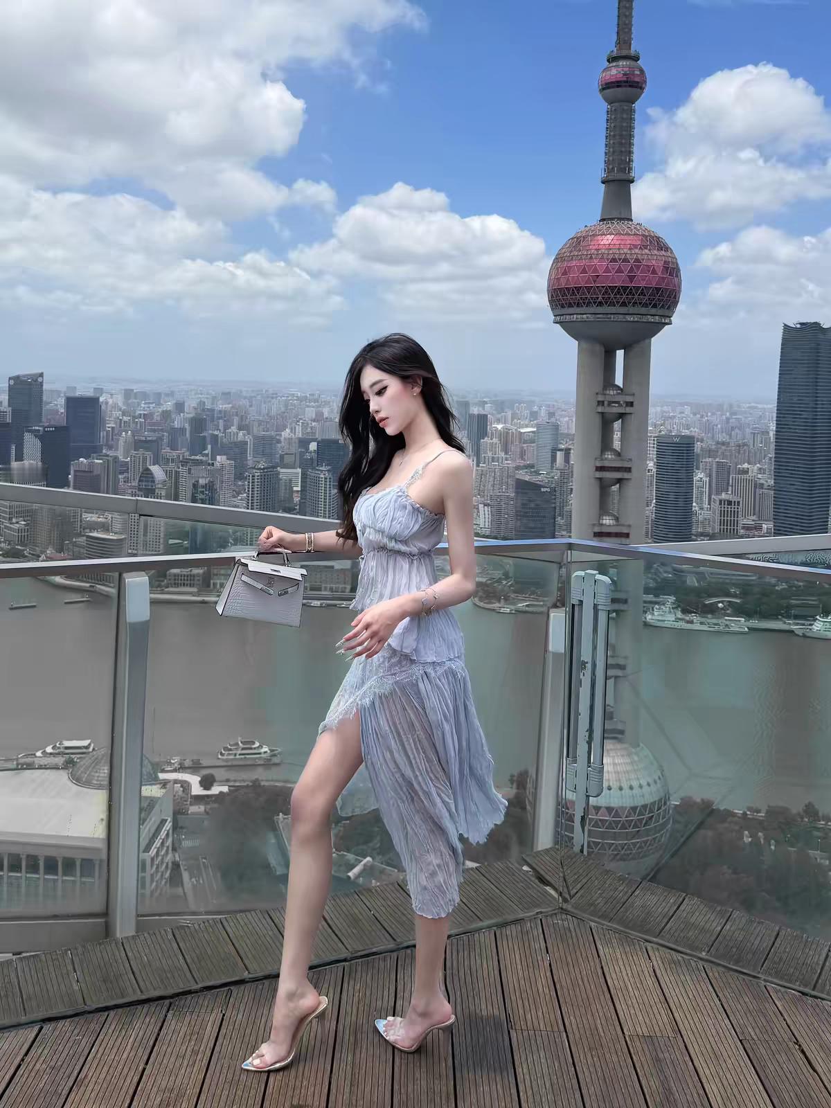 姐妹们！这件浅蓝吊带裙+透明高跟的组合，真的绝了！
在东方明珠露台拍出来，直接封