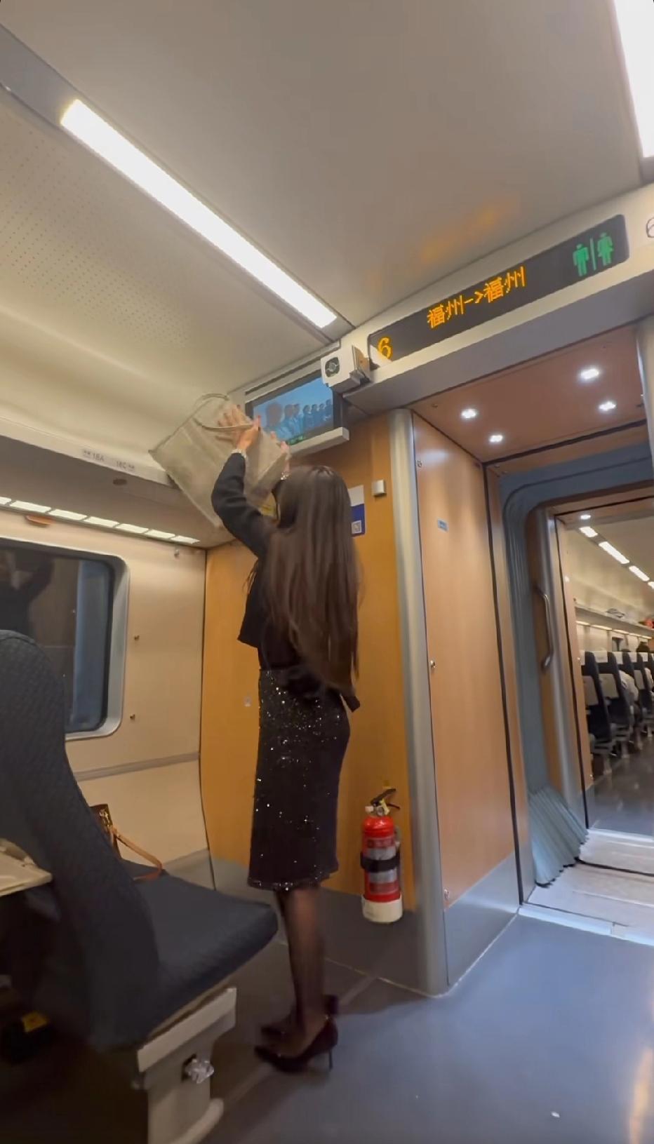 在高铁上，一个美女要下车了，放在高处行李架上的物品，也是自己一个女人勉强去够着拿