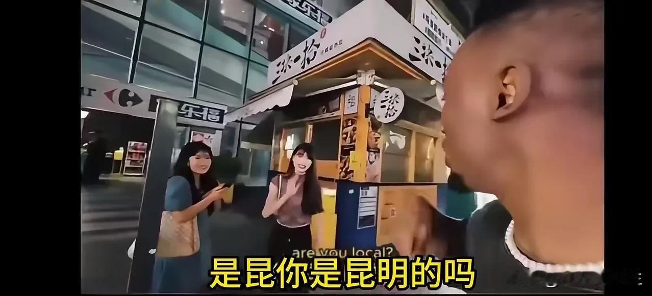 两名中国女孩正在等自己的男朋友，正好遇到一位非洲小伙的搭讪，当得知中国女孩有男朋