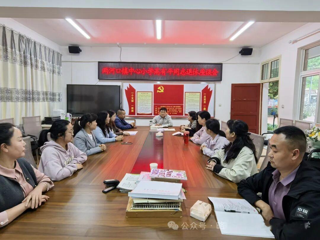 陕西略阳县两河口镇中心小学举行高有平老师光荣退休欢送仪式，黄术君老师为高老师献上