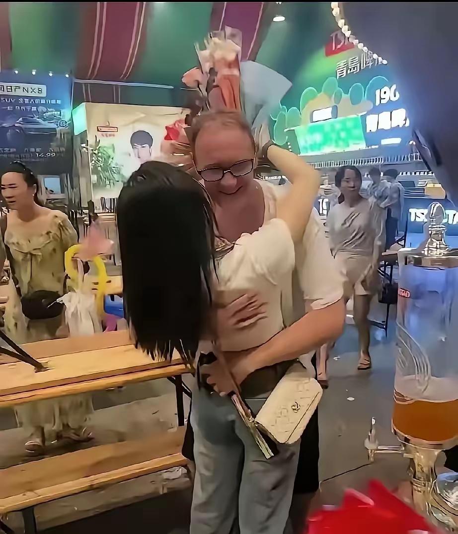 一个外国中年男人，头发有点稀疏，肚子微微腆着，穿着件宽松的短袖衬衫，正和一个看着
