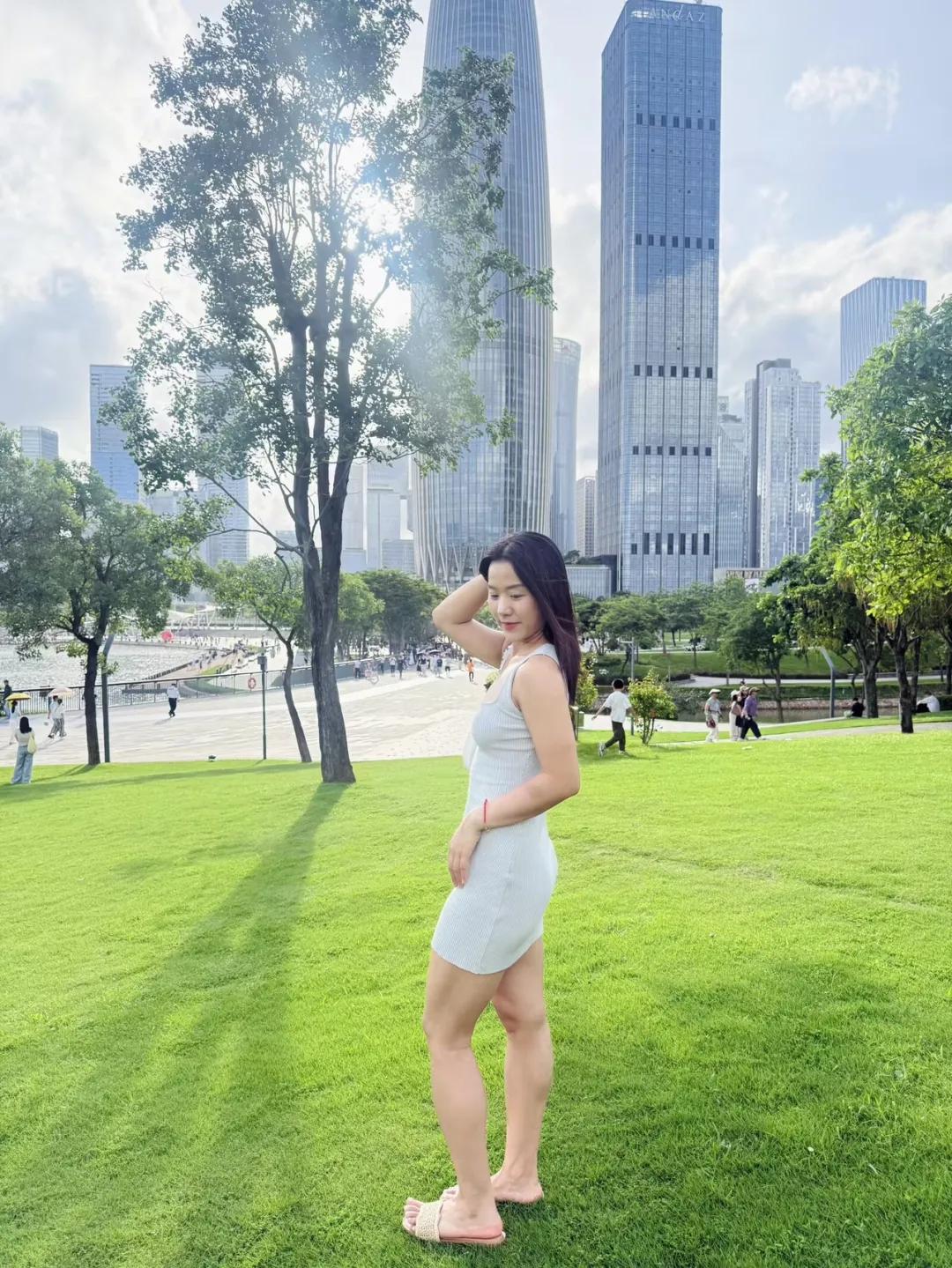 阳光明媚，她在绿地上拍照。