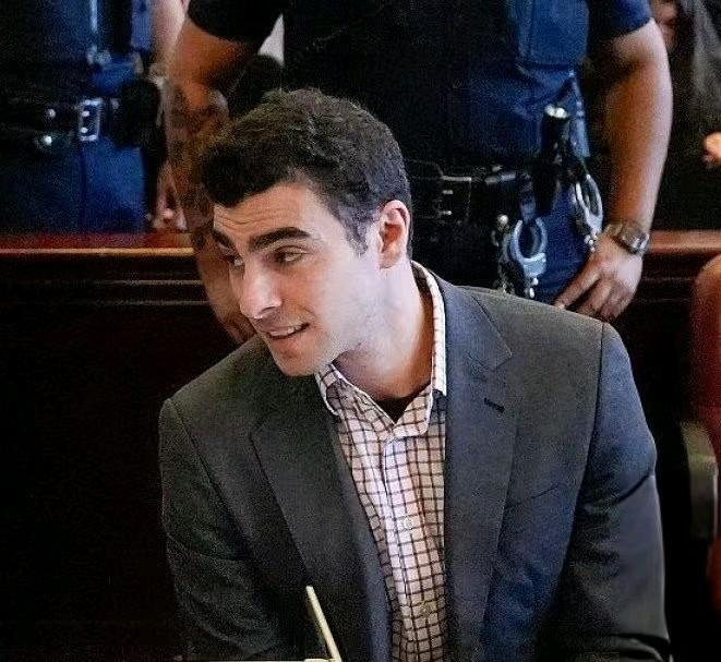 路易吉每次出庭都有人安排他的穿搭，这次的造型有点显老，反而将后面左侧的男押解员衬