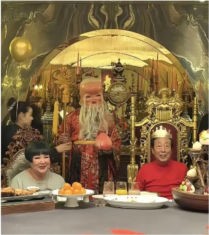 镜头中穿着红衣戴着生日帽的曲艺泰斗韩宝利气色盈和，笑意粲然；一旁的徒弟王惠面如满