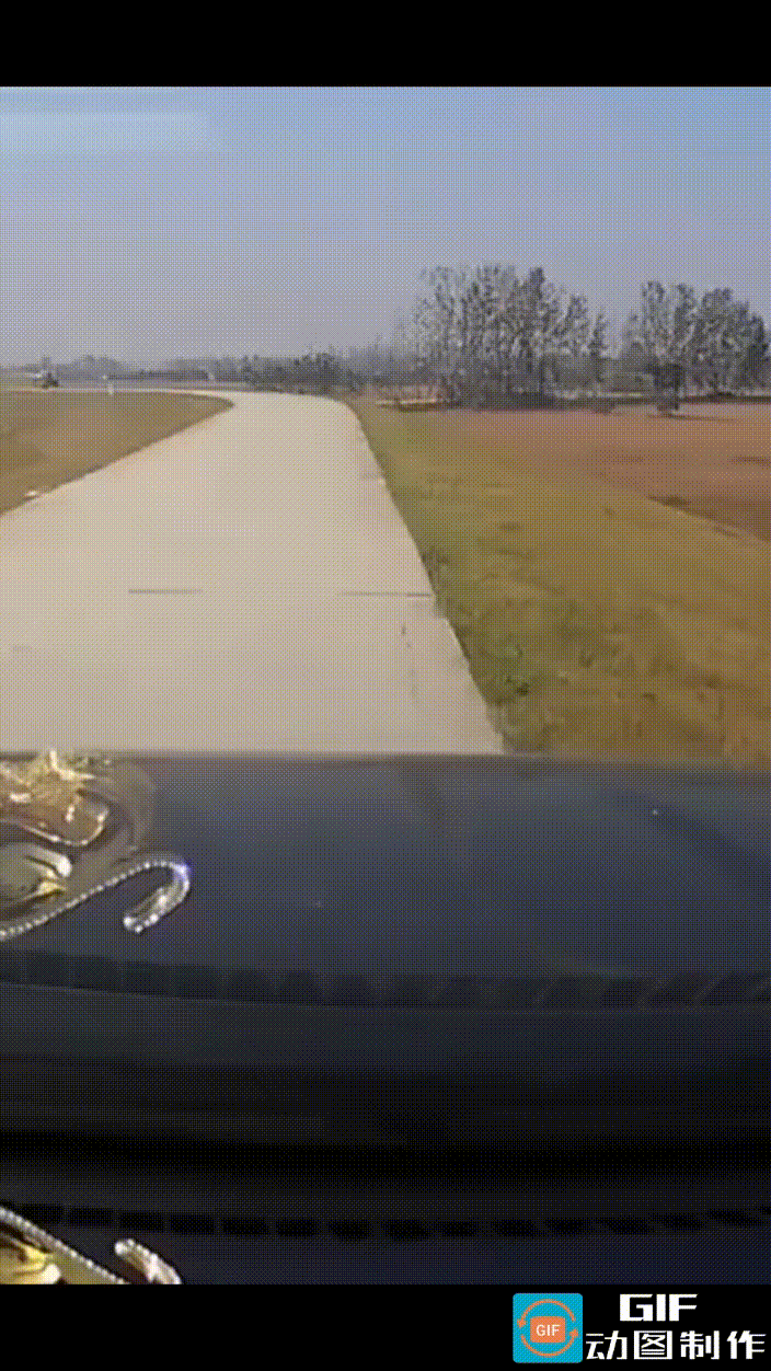 男子驾车从堤坝上经过，前方道路上，老人正违规占用道路晒粮，在视频车距老人晒粮处还