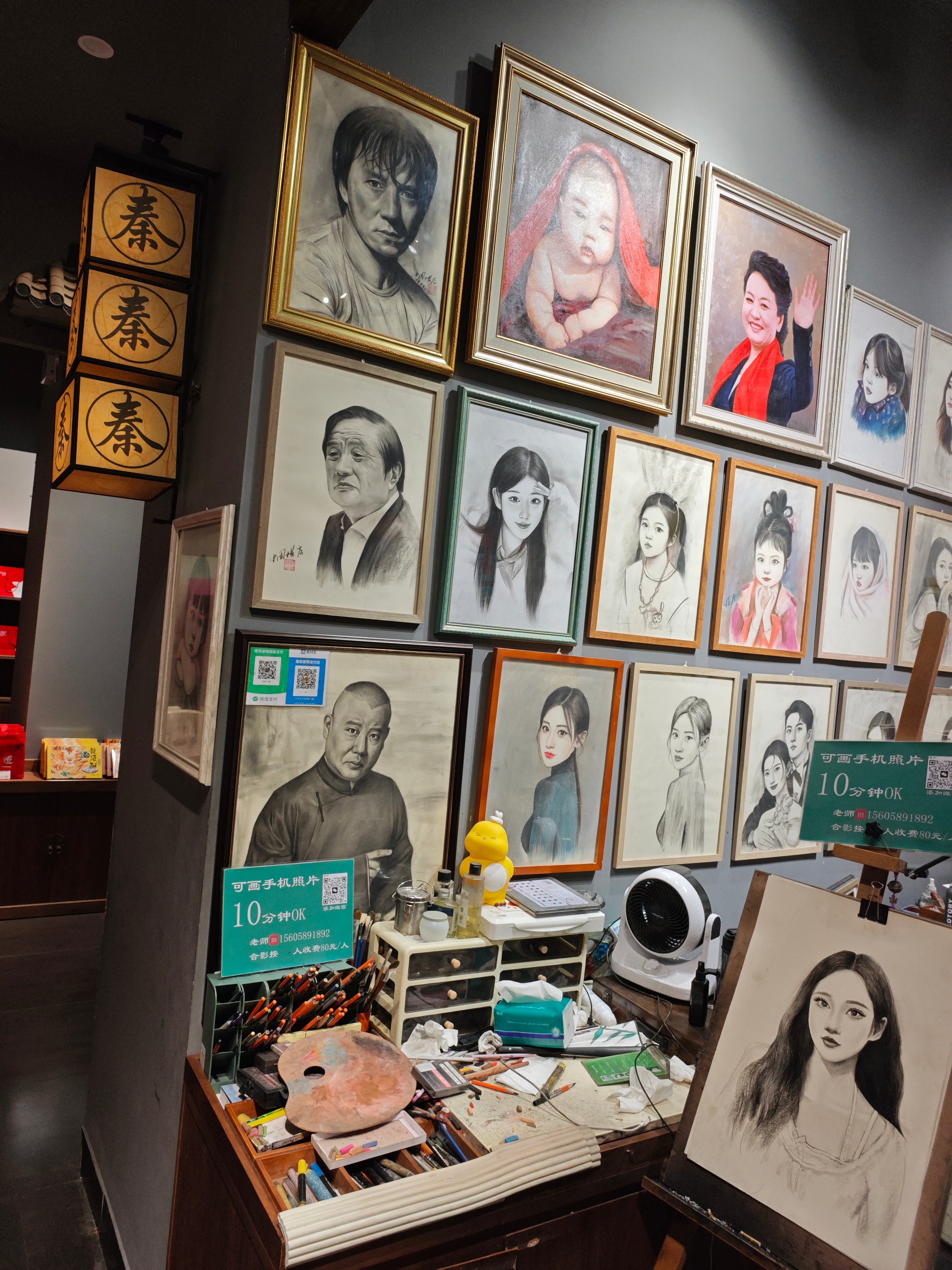 一家给游客画个人画像的店，他们的案例在C位摆放的是华为任正非的画像。原来任正非在