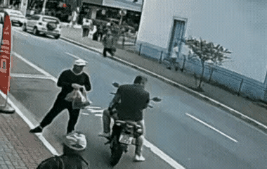 一位帅哥和骑摩托车的朋友，站在公路边抽烟闲聊，突然听到有人大声喊:抓小偷，抓小偷