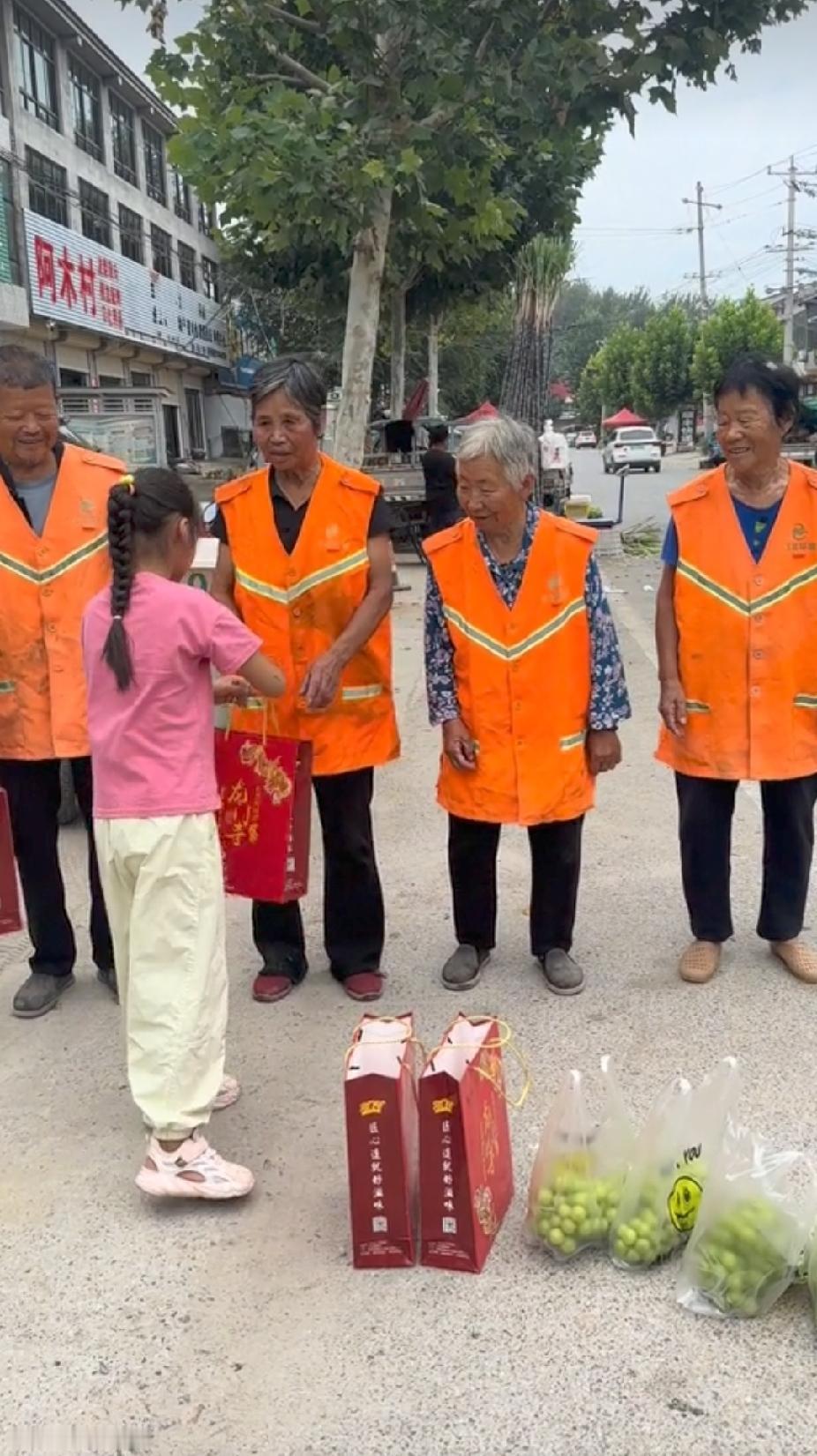 一位小女孩，将正在街边干活的几名环卫工老人拉到路边，接下来的一幕，让人看着直呼感