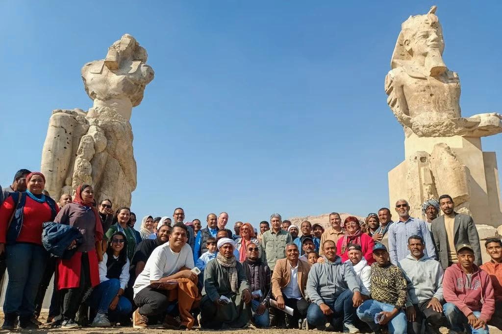 埃及旅游和文物部长谢里夫·法西(中)和古迹修复人员，在法老雕像前合照。(欧新社照