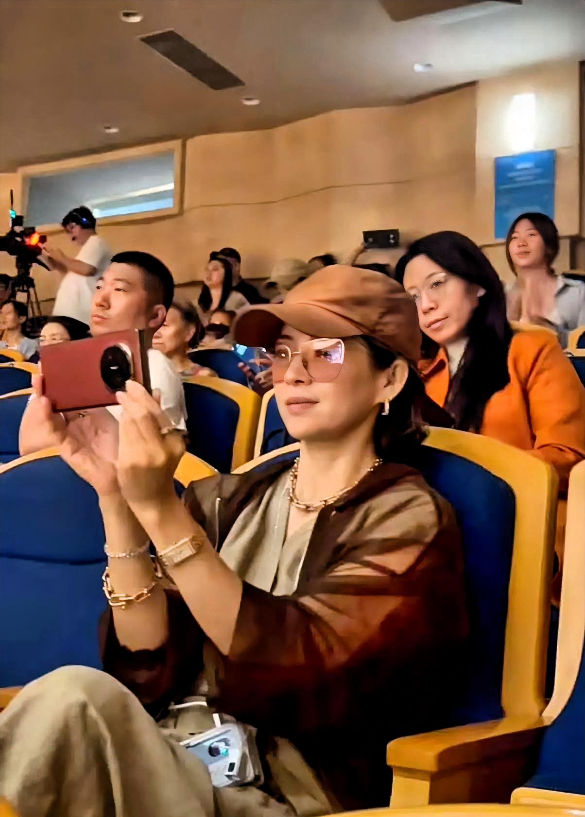 章子怡坐在台下，手机举了整整三首歌。

不是媒体镜头对着她的那种举法。是当妈的那