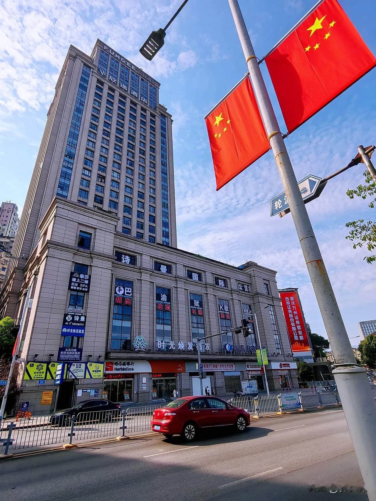 万州区北滨路两边人行道上，电杆上鲜红的红旗，迎风飘扬，红红火火喜迎国庆节！